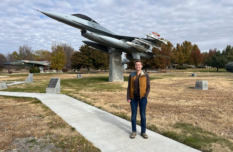 A woman stands in front of a fighter jet on display at Mountain Home Air Force Base in Idaho.