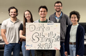 members of a group called the data strike team hold a sign that reads "data strike team 2025"